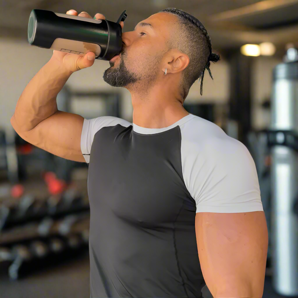 Man drinking from a black shaker bottle on a white background